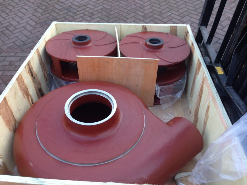 Grote zandgietdelen verpakt in houten kist, klaar voor transport