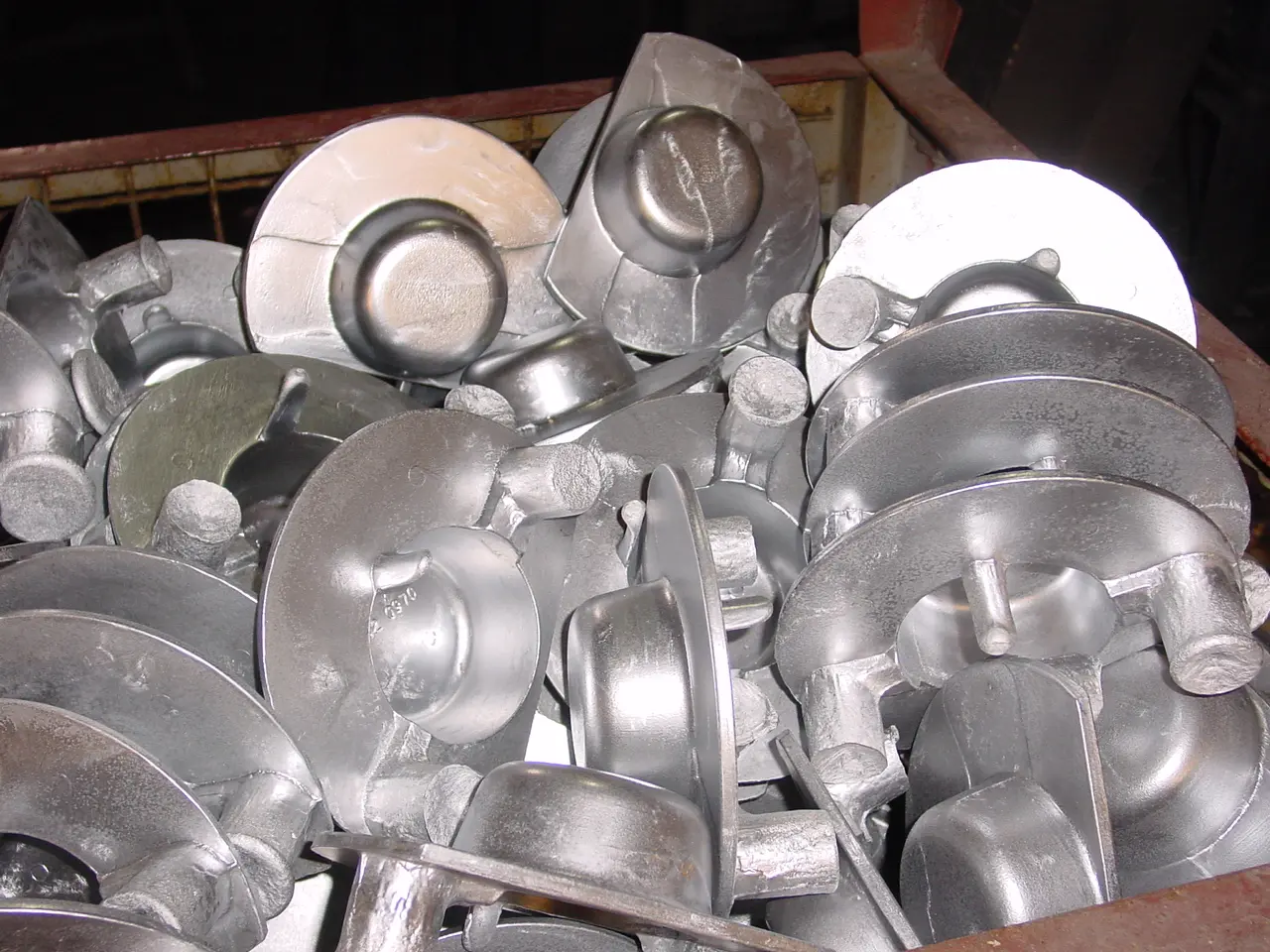 Aluminium gietstukken na het coquillegieten, verzameld in krat bij TOS