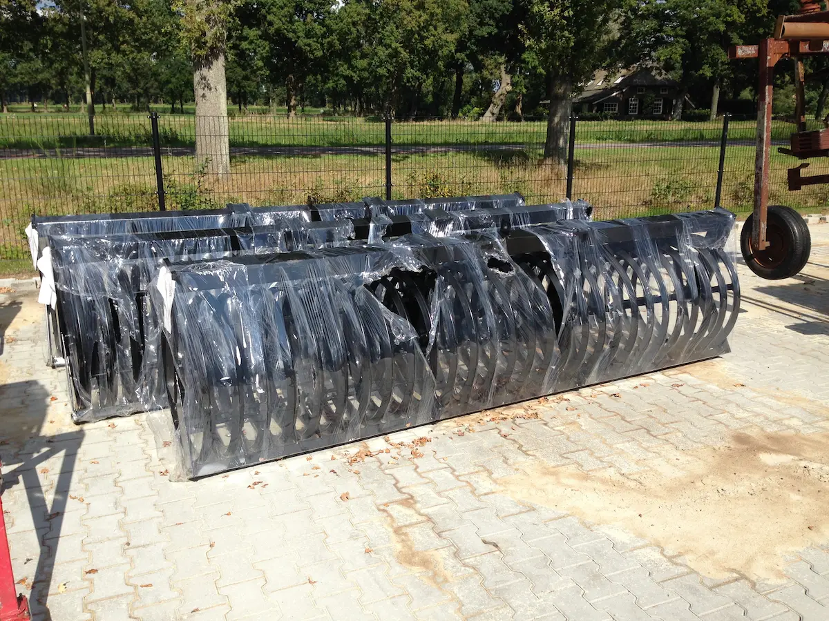 Gecoate en geassembleerde rollenframes voor akkerbouwmachines, gelast en verpakt voor levering.